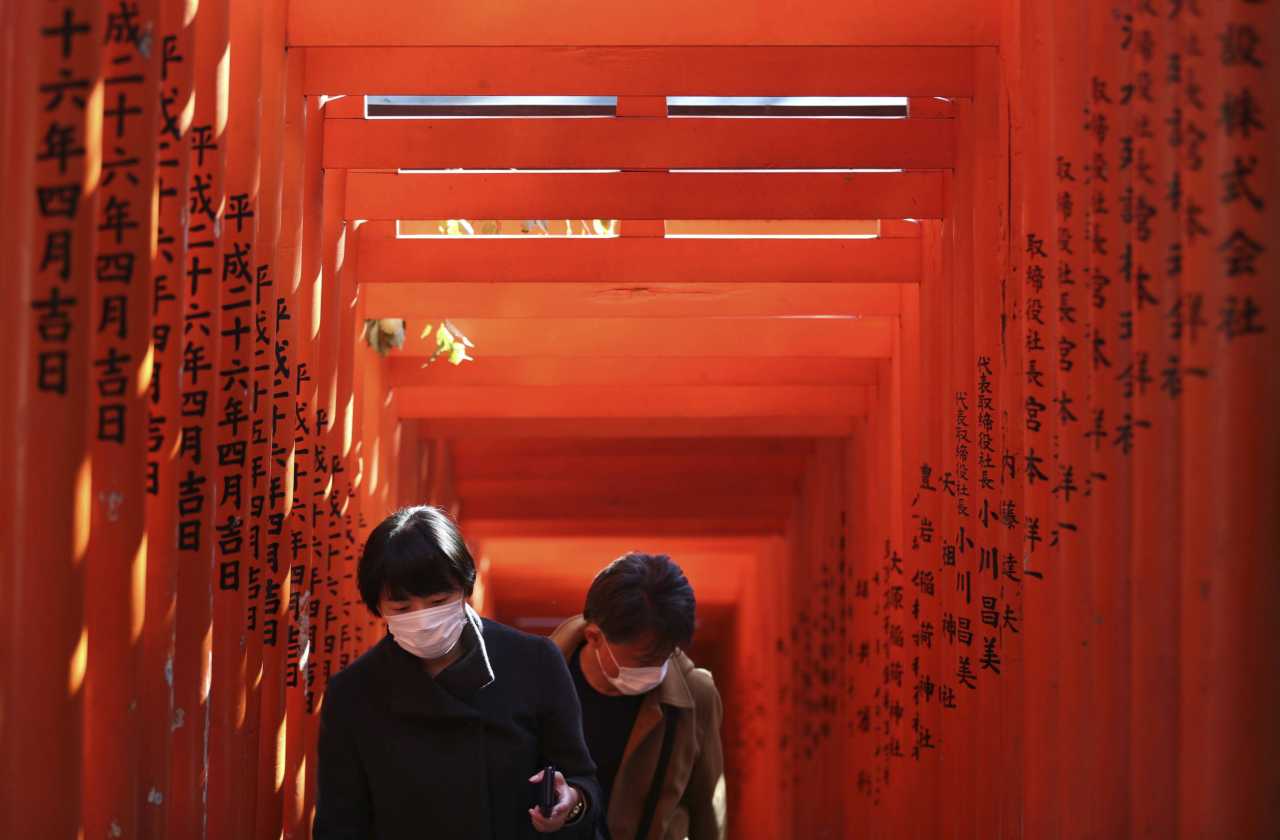 Mask-wearing people visit a shrine in Tokyo on March 19, 2020, amid an outbreak of the new coronavirus COVID-19. (c) Sipa AP22439852_000052