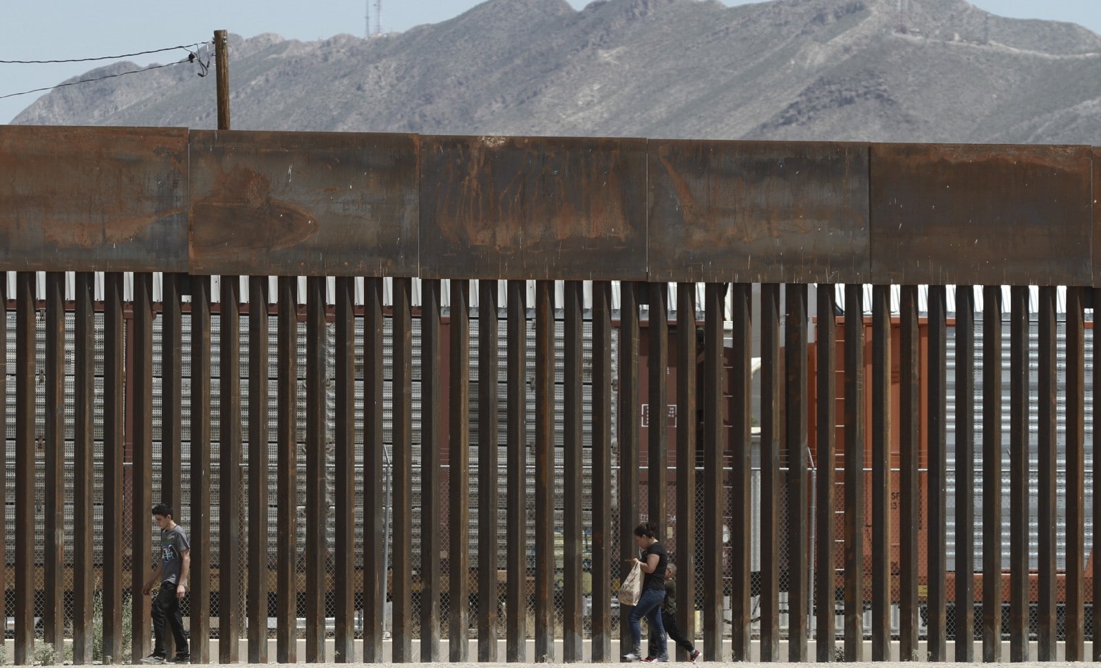 Le 17 juillet 2019, des migrants qui sont parvenus à échapper à la gade mexicaine, marchent le long du mur qui fait la frontière avec les Etats-Unis © Christian Chavez/AP/SIPA Numéro de reportage  : AP22393703_000001