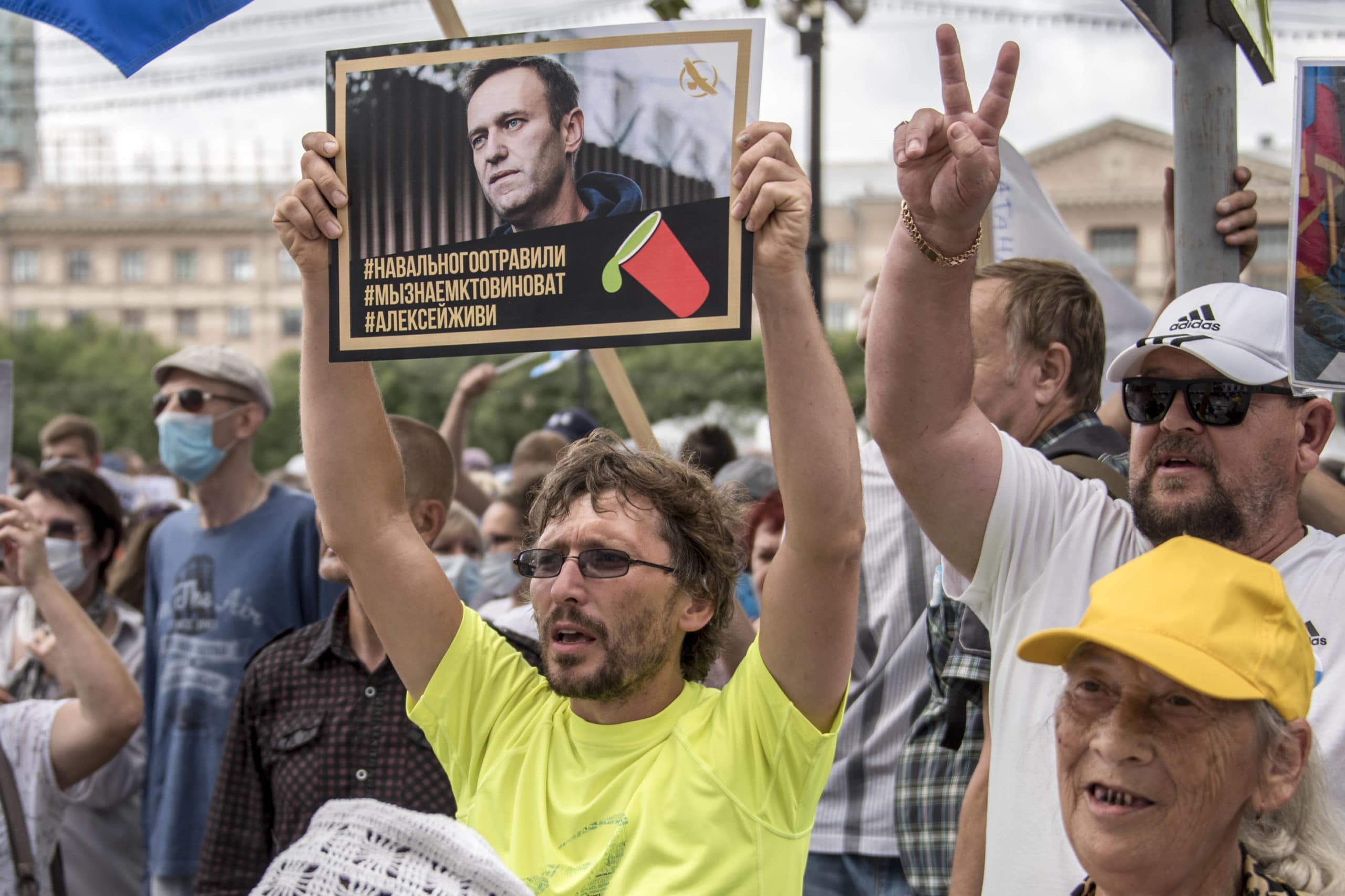 A man holds a poster with a portrait of Alexei Navalny reading "Navalny was poisoned, we know who is to blame, Alexei you must live" during an unsanctioned protest in support of Sergei Furgal, the governor of the Khabarovsk region, in Khabarovsk, 6,100 kilometers (3,800 miles) east of Moscow, Russia, Saturday, Aug. 22, 2020. Russian dissident Alexei Navalny, who is in a coma after a suspected poisoning, has arrived in Berlin on a special flight for treatment by specialists. The politician and corruption investigator who is one of Russian President Vladimir Putin's fiercest critics was thought to be in stable condition on arrival Saturday and is to be treated in the German capital's main hospital. (AP Photo/Igor Volkov)/XAZ105/20235398218764//2008221304