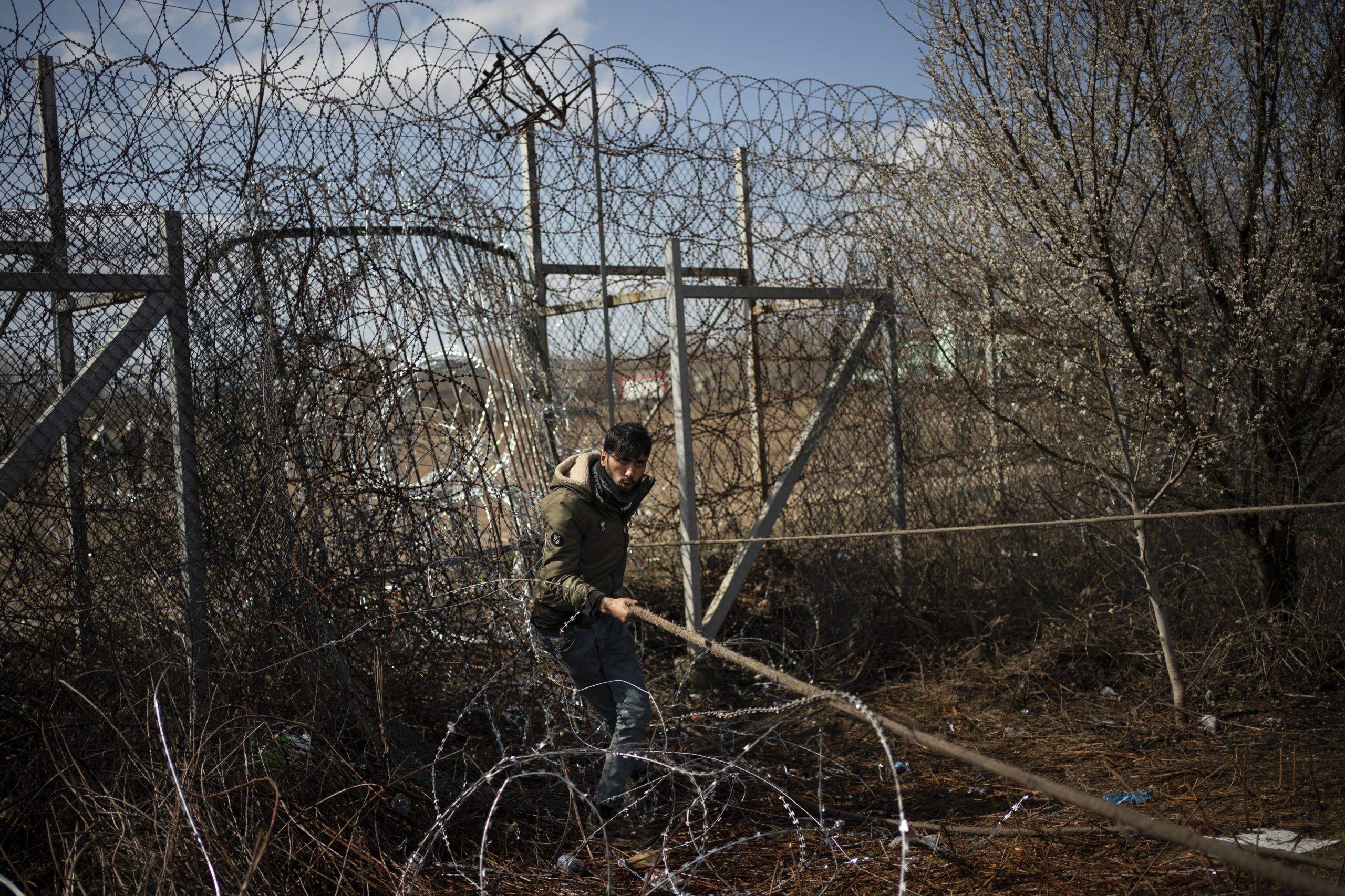 Un migrant tente d'enlever la clôture du côté turc lors d'affrontements avec la police anti-émeute et l'armée grecque à la frontière turco-grecque à Pazarkule (c) Sipa AP22435918_000031