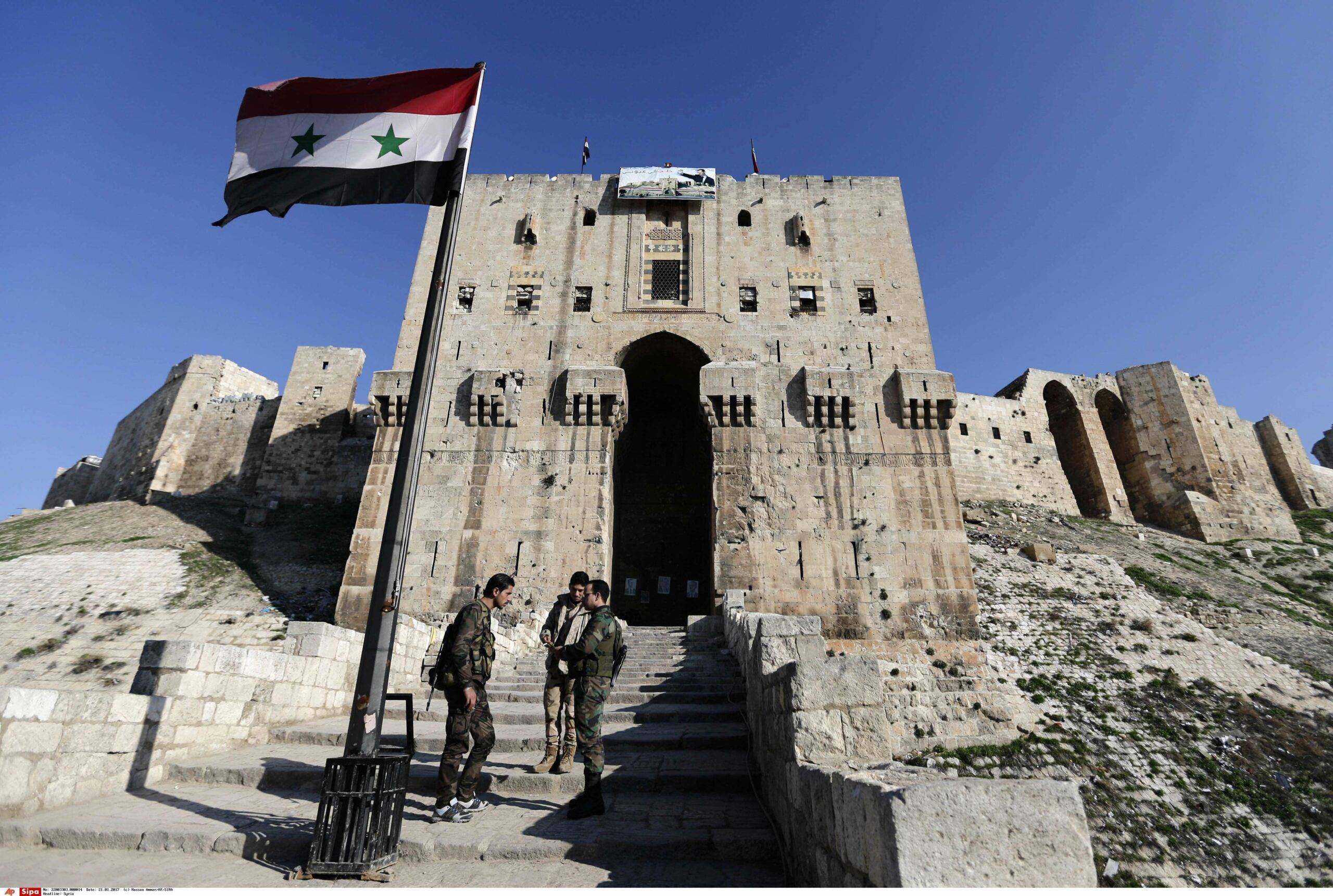 Syrian soldiers stand guard at the main gate of the ancient Aleppo Citadel that government troops used as a military base in the old city of Aleppo, Syria, Saturday, Jan. 21, 2017. Thousands of people have returned to their homes in east Aleppo that was held by rebels for more than four years until government forces took full control of it last month. East Aleppo has suffered wide destruction because of airstrikes and shelling. (AP Photo/Hassan Ammar)/HAS110/17021560865106/1701211700