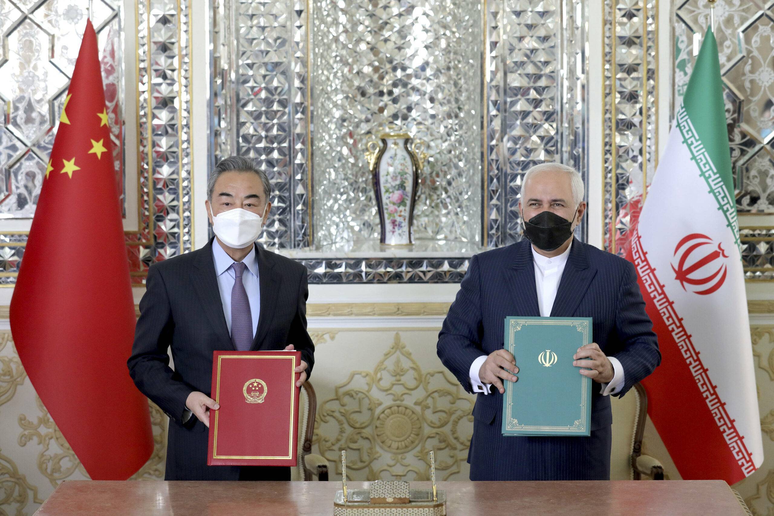 Iranian Foreign Minister Mohammad Javad Zarif, right, and his Chinese counterpart Wang Yi, pose for photos after the ceremony of signing documents, in Tehran, Iran, Saturday, March 27, 2021. Iran and China on Saturday signed a 25-year strategic cooperation agreement addressing economic issues amid crippling U.S. sanctions on Iran, state TV reported. (AP Photo/Ebrahim Noroozi)/ENO101/21086438952424//2103271321