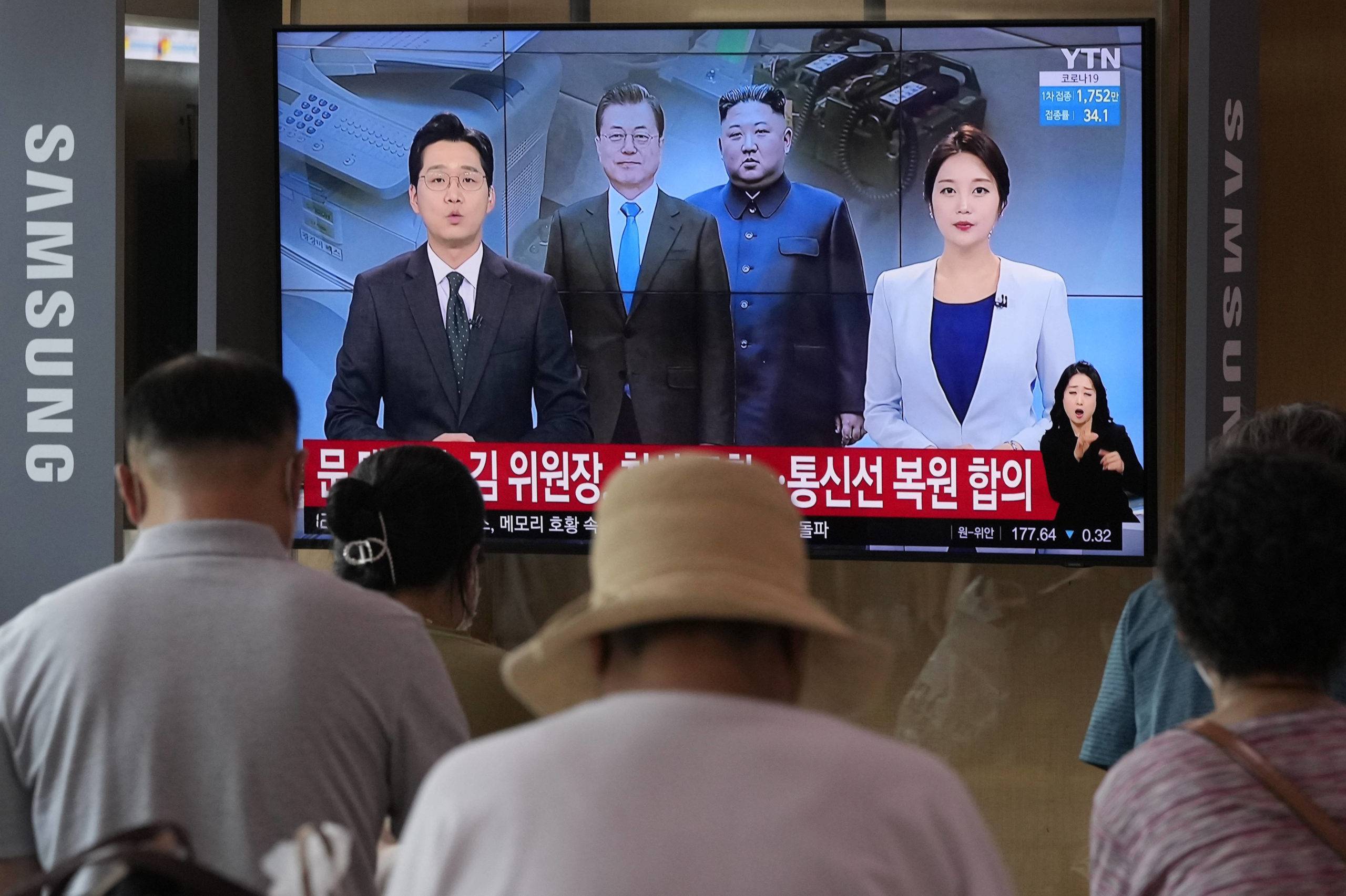 A TV shows a file image of North Korean leader Kim Jong Un, third from left, and South Korean President Moon Jae-in, second from left, during a news program at the Seoul Railway Station in Seoul, South Korea, Tuesday, July 27, 2021. North and South Korea restored suspended communication channels between them and their leaders agreed to improve ties, both governments said Tuesday, despite a 2 ½ year-stalemate in U.S.-led diplomacy aimed at stripping North Korea of its nuclear weapons. Korean letters read: "Moon Jae-in and Kim Jong Un agreed to restore communication channels." (AP Photo/Ahn Young-joon)/SEL103/21208165186177//2107270645