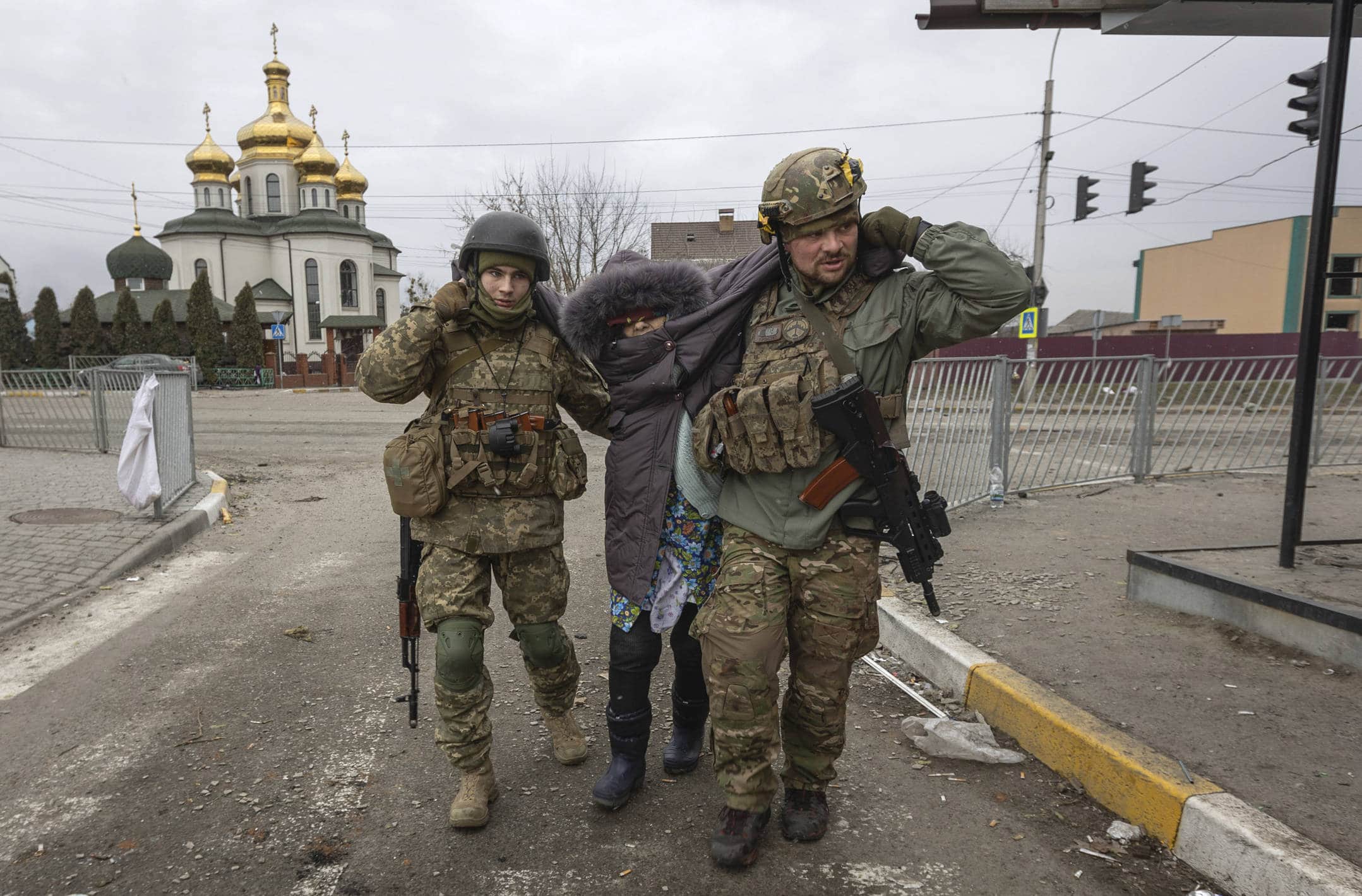 Ukrainian servicemen help an elderly woman, in the town of Irpin, Ukraine, Sunday, March 6, 2022. Photo/Andriy Dubchak)/MAD105/22065459139535//2203061400