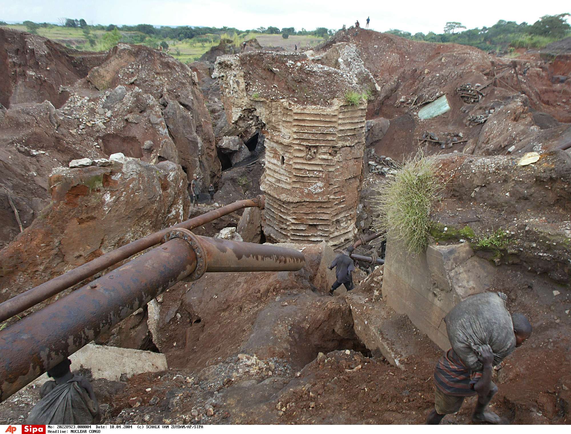 A Jung man carries whet cobalt on his back in this view of the Shinkolobwe Cobalt mine outside of the town of Likasi, in southeastern Democratic Republic of Congo, April 10, 2004. Amid world terror fears and concerns about unregulated nuclear materials, Congo's president issued a strict decree: The mining zone that provided uranium for the atomic bombs America unleashed on Hiroshima and Nagasaki must close immediately.(AP Photo/Schalk van Zuydam)/NUCLEAR_CONGO_NY467/0405310157