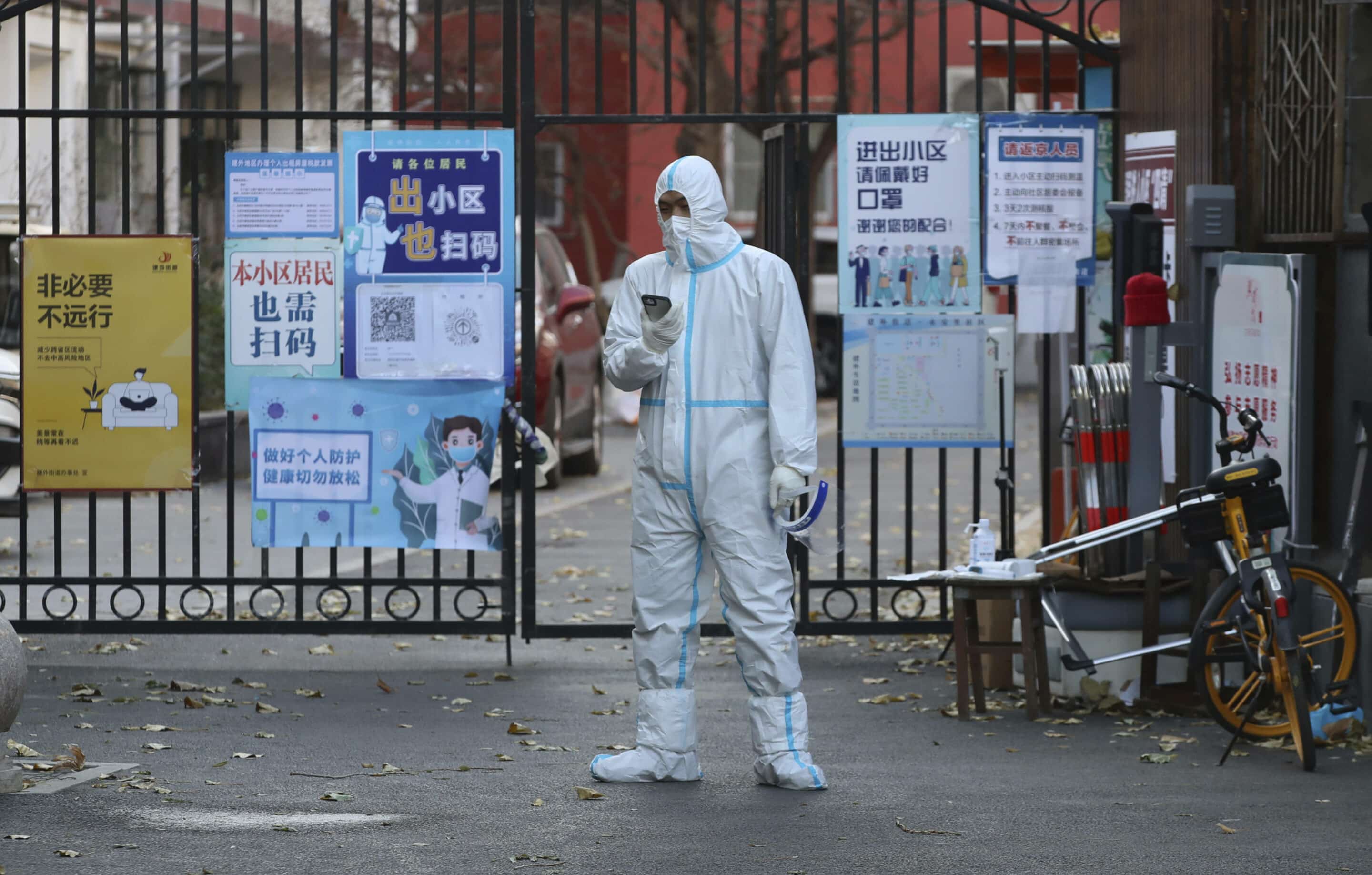 A medical staff wearing a protective suit sets up a barricade at a closed housing complex in order to prevent widespread COVID-19 in Beijing, China on Nov. 29, 2022. ( The Yomiuri Shimbun via AP Images )/YOMIU/22333549511461/JAPAN OUT/2211291622