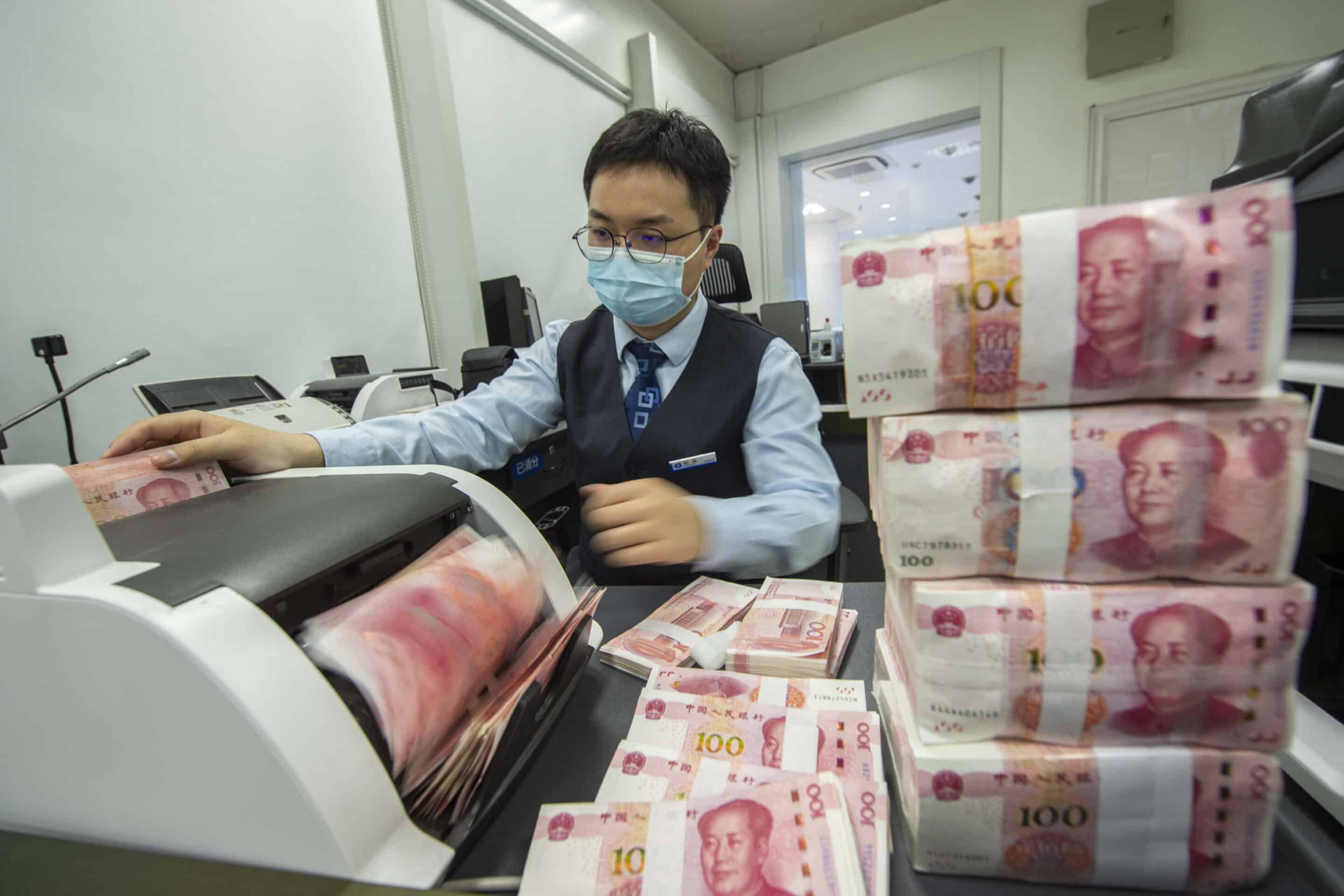 HAIAN, CHINA - MAY 15, 2022 - A staff member counts renminbi(RMB)  at a bank in Haian, Nantong city, East China's Jiangsu province, May 15, 2022. According to the People's Bank of China (PBOC), the INTERNATIONAL Monetary Fund (IMF) Executive Board unanimously raised the weighting of the RENMINBI (RMB) from 10.92 percent to 12.28 percent after completing its quennial review of the valuation of Special Drawing Rights (SDR), up 1.36 percentage points. (Photo by CFOTO/Sipa USA)/39301948//2205151535