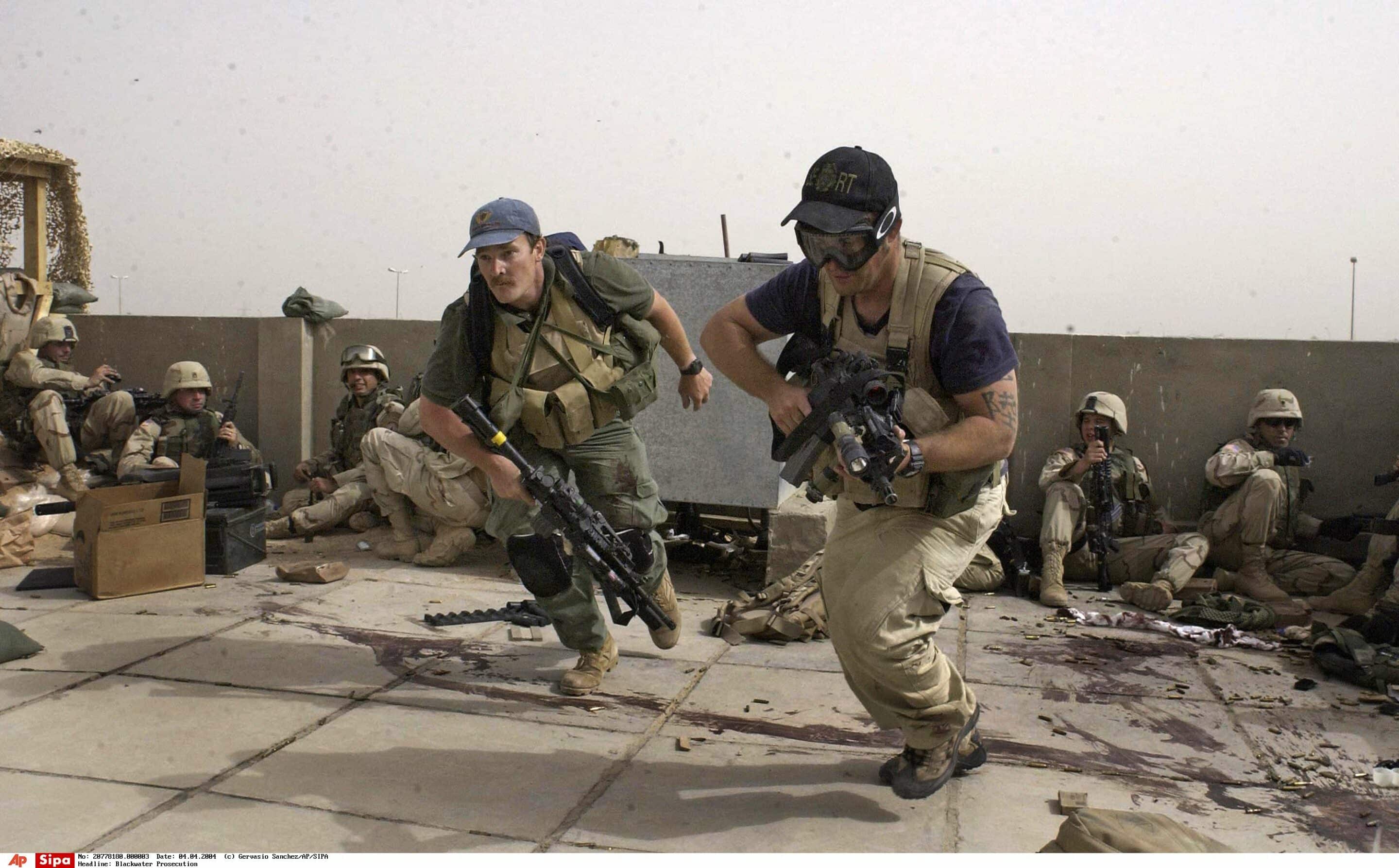 ** FILE  ** Plainclothes contractors working for Blackwater USA take part in a firefight as Iraqi demonstrators loyal to Muqtada Al Sadr attempt to advance on a facility being defended by U.S. and Spanish soldiers in Najaf, Iraq in this April 4, 2004 file photo. The Blackwater USA contractors were actively involved in defending the position.  (AP Photo/Gervasio Sanchez, File)/Blackwater_Prosecution_WX107/AN APRIL 4, 2004 FILE PHOTO/0812050452