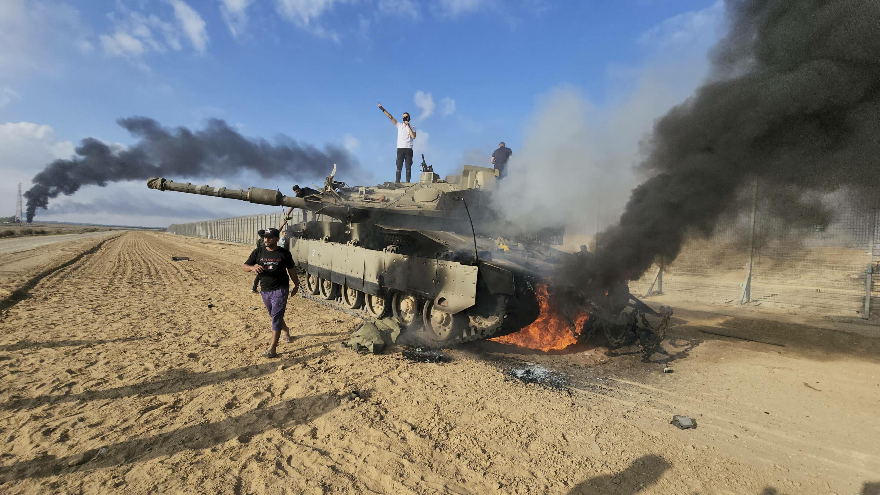 Des Palestiniens célébrant leur victoire sur un char israélien.(AP Photo/Hassan Eslaiah)